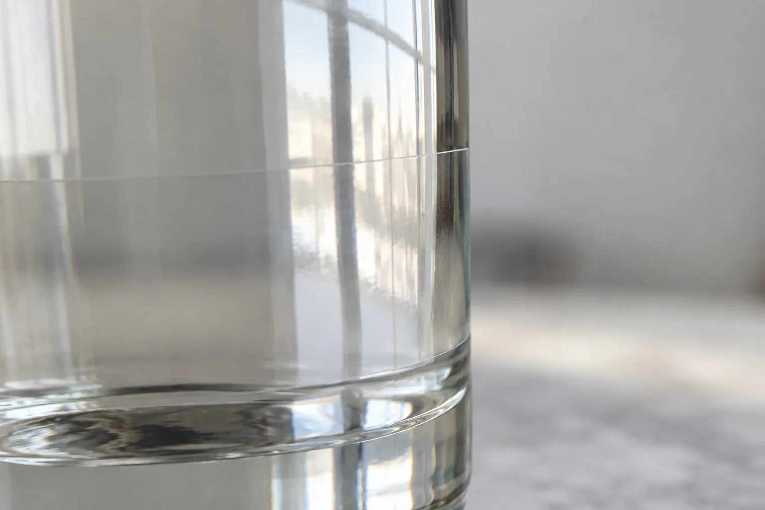 Detalhe da borda de uma etiqueta transparente acompanhando a curva do vidro